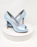 A pair of high heeled baby blue satin shoes with a peep toe and a hidden platform at the front of the shoes