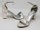 A pair of white satin block heel shoes with an ankle strap