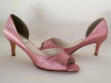 A pair of dusty rose satin medium height heel shoes with a peep toe
