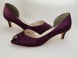 A pair of eggplant purple low heel satin kitten heel shoes with a peep toe