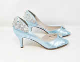A pair of baby blue satin medium height heel shoes with a peep toe and designed with a crystal design on the front of the shoes and a crystal design on the back of the shoes heel