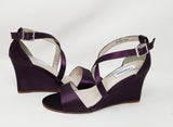 A pair of eggplant purple wedding shoes with high wedge and straps across the front of the foot
