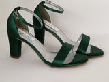 A pair of hunter green block heel shoes with an ankle strap