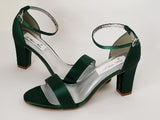 A pair of hunter green block heel shoes with an ankle strap