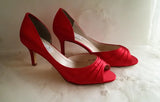 A pair of red satin medium height heel shoes with a peep toe