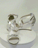 A pair of ivory wedding shoes with high wedge and straps across the front of the foot designed with a crystal design on the front toe strap and a crystal design on the back heel of the shoes