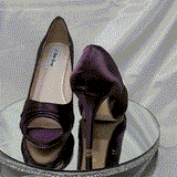 A pair of high heeled eggplant satin shoes with a peep toe and a hidden platform at the front of the shoes