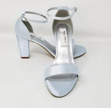 A pair of baby blue block heel shoes with an ankle strap 