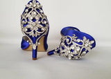 A pair of royal blue satin medium height heel bridal shoes with a peep toe and designed with a crystal design on the front of the shoes and a crystal design on the back heel of the shoes