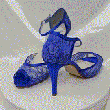 A pair of royal blue lace high heeled shoes with a front hidden platform and an ankle strap with a peep toe