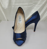 A pair of high heeled navy blue satin shoes with a peep toe and a hidden platform at the front of the shoes