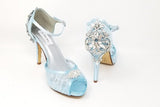 A pair of baby blue high heeled platform lace shoes with an ankle strap and a crystal design on the front of the peep toe shoe and a crystal design on the back heel of the shoes