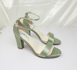 A pair of sage green block heel shoes with an ankle strap