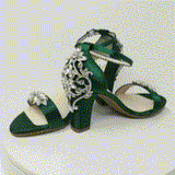 A pair of hunter green block heel shoes with an ankle strap and a crystal design on the front toe strap of the shoes and a crystal design on the heel of the shoes