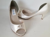 A pair of ivory satin kitten heels with a peep toe and designed with a crystal design on the front of the shoes
