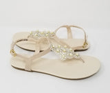 a pair of flat heel ivory bridal sandals with pearls snf crystals on the straps of the sandals