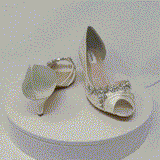 a pair of ivory low heels with a peep toe front and a crystal vine design across the front and side of the shoes