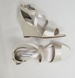 A pair of ivory wedding shoes with high wedge and straps across the front of the foot