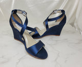A pair of navy blue wedding shoes with high wedge and straps across the front of the foot