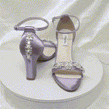 A pair of lilac purple block heel shoes with an ankle strap and a crystal and pearl design on the front toe strap of the shoes and a crystal and pearl design on the heel of the shoes