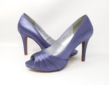A pair of high heeled lilac purple satin shoes with a peep toe and a hidden platform at the front of the shoes