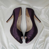 A pair of high heeled eggplant satin shoes with a peep toe and a hidden platform at the front of the shoes