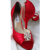 A pair of red satin medium height heel shoes with a peep toe and designed with a crystal design on the front of the shoes and a crystal design on the back heel of the shoes