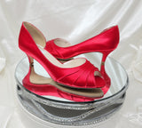 A pair of red satin kitten heel shoes with a peep toe