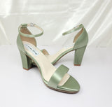 A pair of sage green block heel shoes with an ankle strap