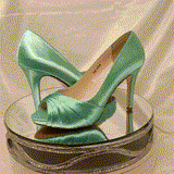 A pair of high heeled aqua blue satin shoes with a peep toe and a hidden platform at the front of the shoes