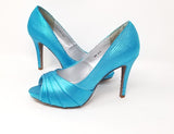 A pair of high heeled turquoise satin shoes with a peep toe and a hidden platform at the front of the shoes