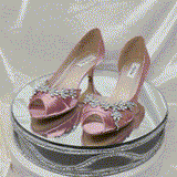 A pair of dusty rose satin kitten heels with a peep toe and designed with a crystal design on the front of the shoes