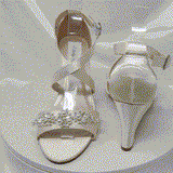 A pair of ivory wedding shoes with high wedge and straps across the front of the foot designed with a pearl and crystal design on the front toe strap of the shoes