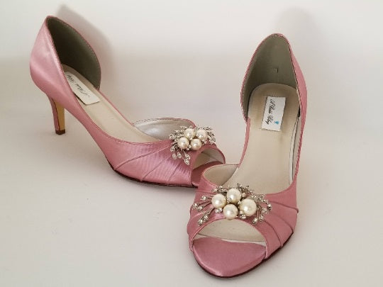 a pair of medium heel dusty rose shoes with a peep toe and a pearl and crystal design on the front of the shoes