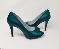 a pair of high heel platform shoes with a peep toe dyed to teal