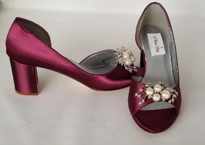 A pair of burgundy shoes with a low block heel and a peep toe front with a crystal and pearl design on the front of the shoes