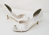 A pair of white satin wedding heels with a peep toe and designed with an all over lace design with pearls