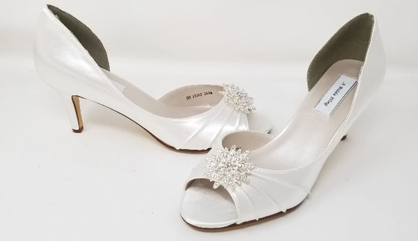 A pair of white satin bridal  heels with a peep toe and designed with a crystal design on the front of the shoes 