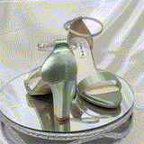 A pair of sage green block heel shoes with an ankle strap