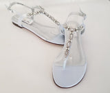 a pair of baby blue flat sandals with a pearl and crystal design on the straps