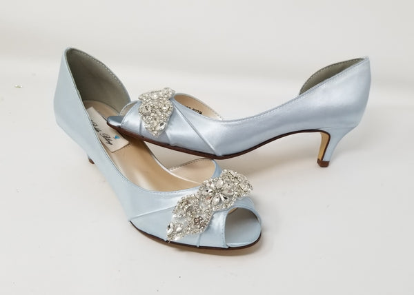 A pair of baby blue satin kitten heels with a peep toe and designed with a crystal design on the front of the shoes