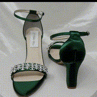 A pair of hunter green block heel shoes with an ankle strap and a crystal design on the front toe strap of the shoes