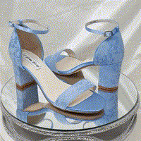 A pair of blue lace covered low block heel shoes with an ankle strap