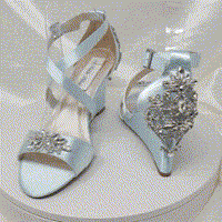 A pair of baby blue wedding shoes with high wedge and straps across the front of the foot designed with a crystal design on the front toe strap and a crystal design on the back heel of the shoes