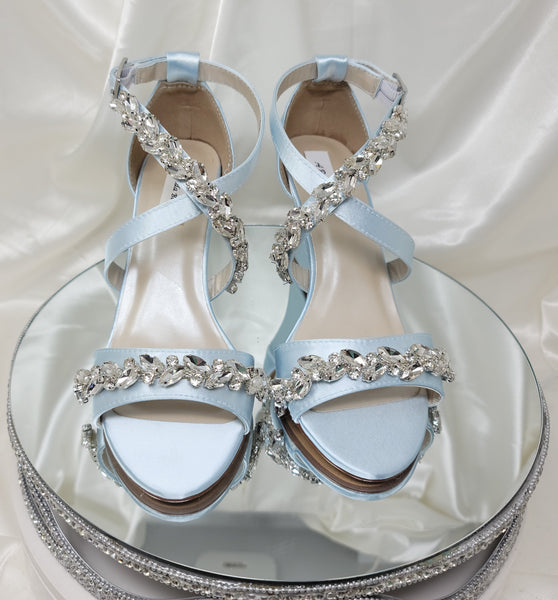 A pair of baby blue wedding shoes with high wedge and straps across the front of the foot designed with a crystal trim design across the straps