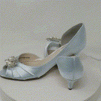 A pair of baby blue satin kitten heels with a peep toe and designed with a pearl and crystal design on the front of the shoes