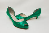 A pair of emerald green low heel satin kitten heel shoes with a peep toe