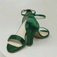 A pair of hunter green block heel shoes with an ankle strap 