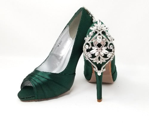 A pair of high heeled hunter green satin shoes with a peep toe and a hidden platform at the front of the shoes and a crystal design on the back heel of the shoes
