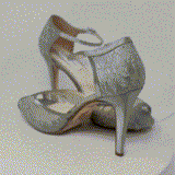 A pair of gray lace high heeled shoes with a front hidden platform and an ankle strap with a peep toe